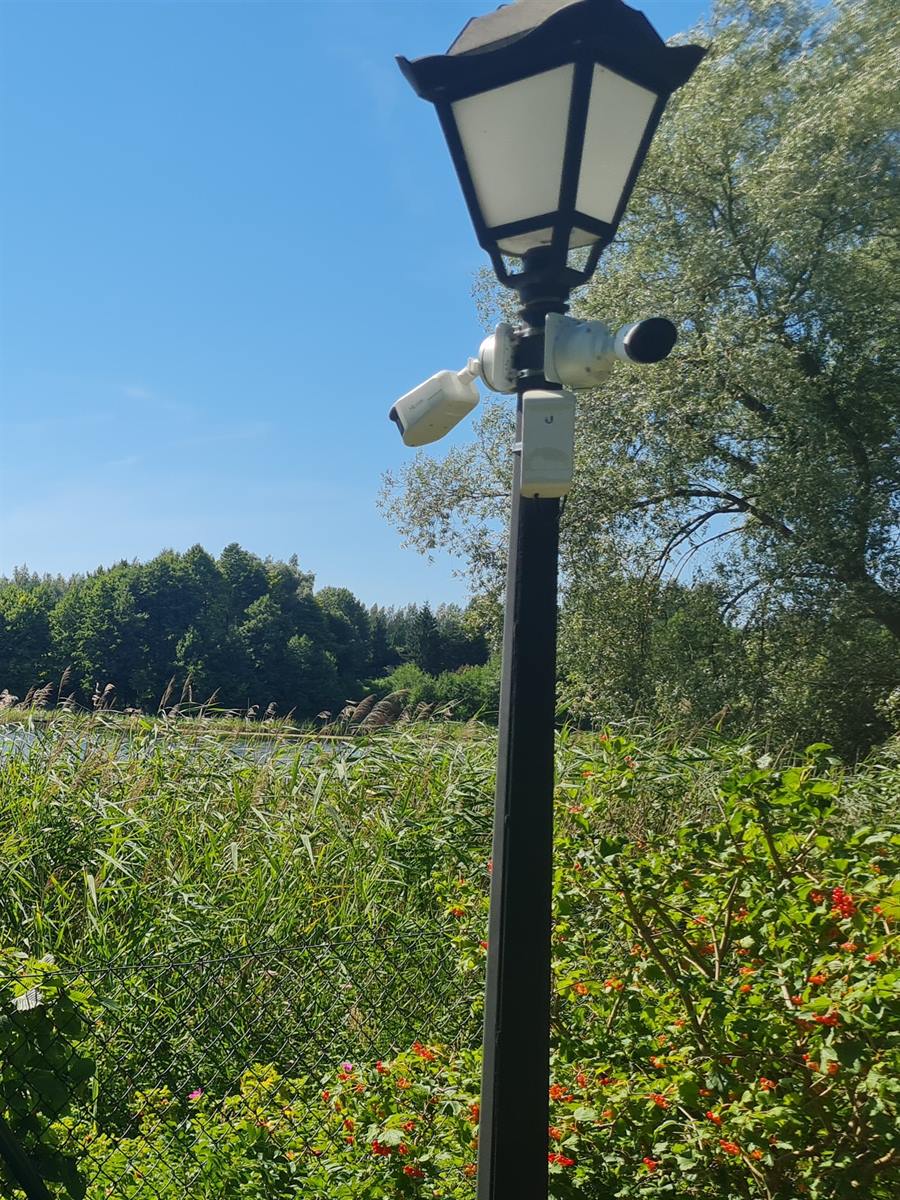 Dwie kamery i punkt Wi-Fi Ubiquiti na latarni na dużej posesji
